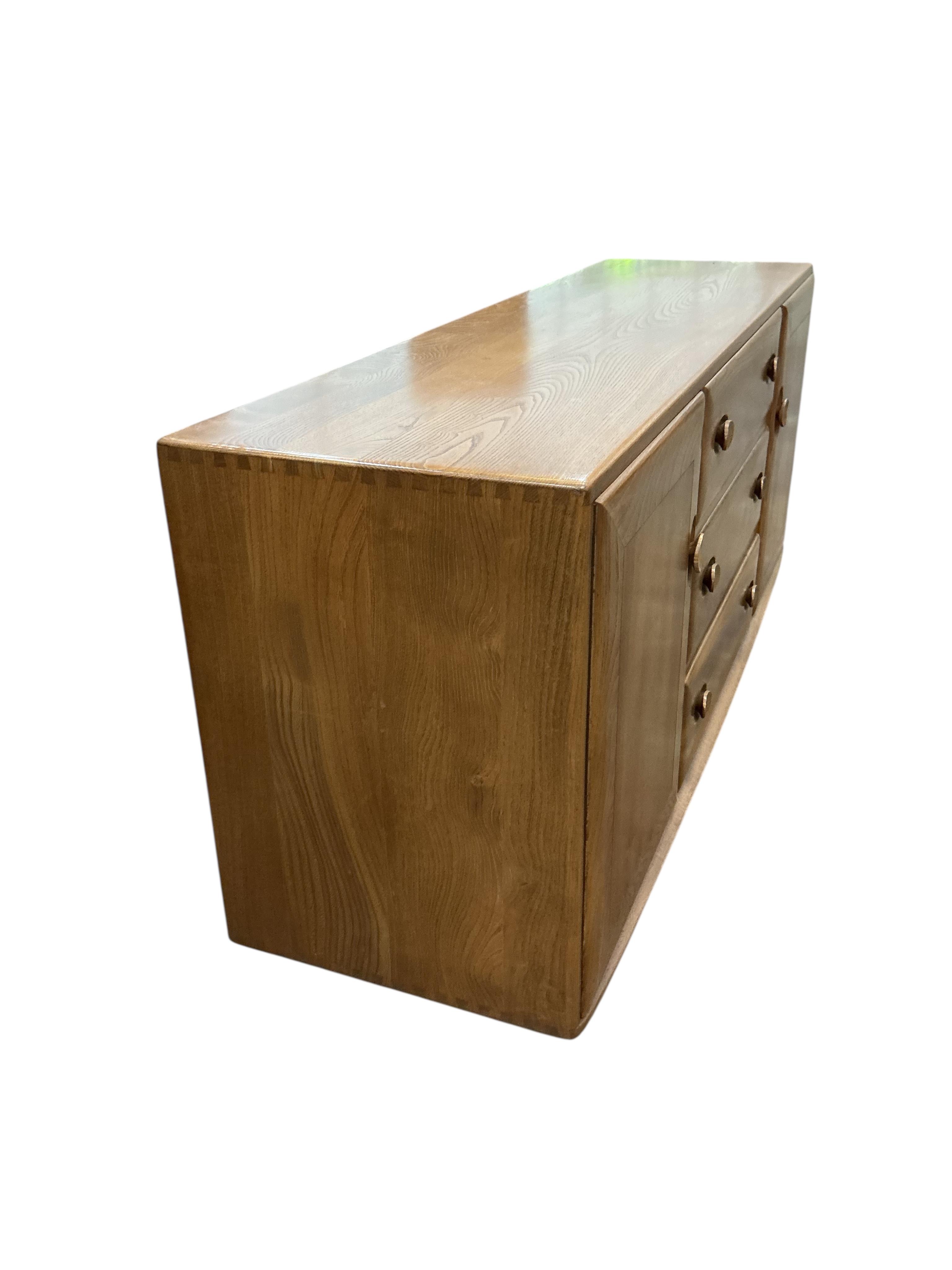 An Ercol Windsor elm sideboard, width 155cm, depth 43cm, height 69cm